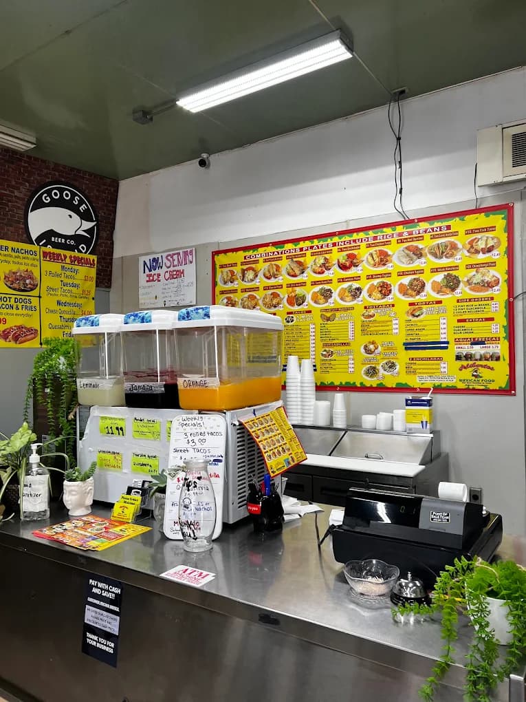 Front counter at Alibertos JR Mexican Food with drink dispensers and a yellow combination plates menu board