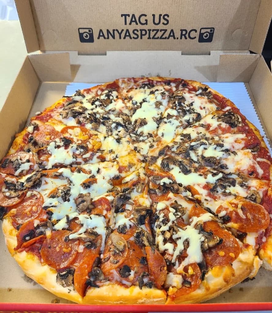 Pepperoni and mushroom pizza in an open takeout box from Anya's Pizza