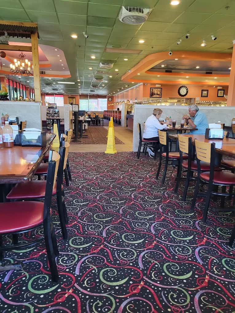 Dining room at Asia Buffet with patterned carpet, red chairs and buffet counters in the back