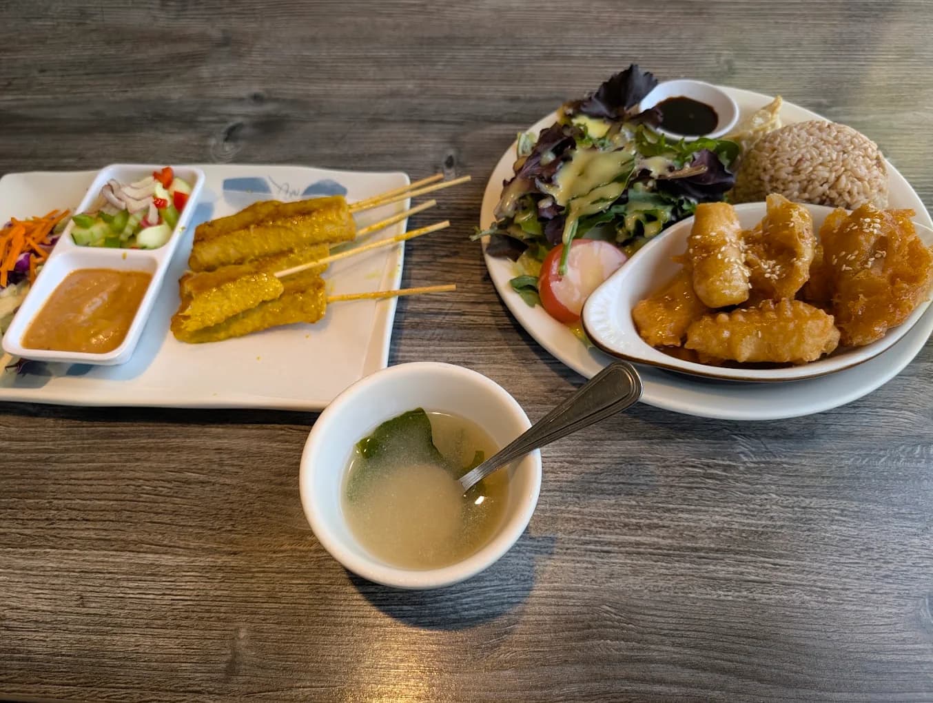 Satay skewers with peanut sauce, a salad with brown rice and fried bites, and soup at Bright Star Thai Vegan