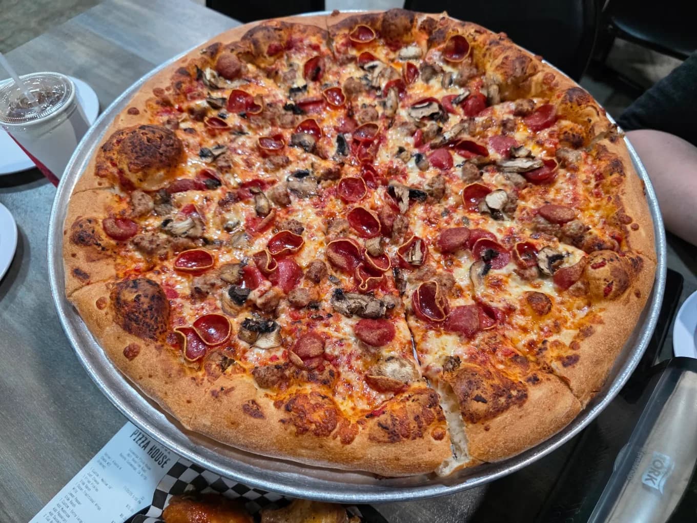 Pepperoni, sausage and mushroom pizza on a metal tray at Cucamonga Pizza House