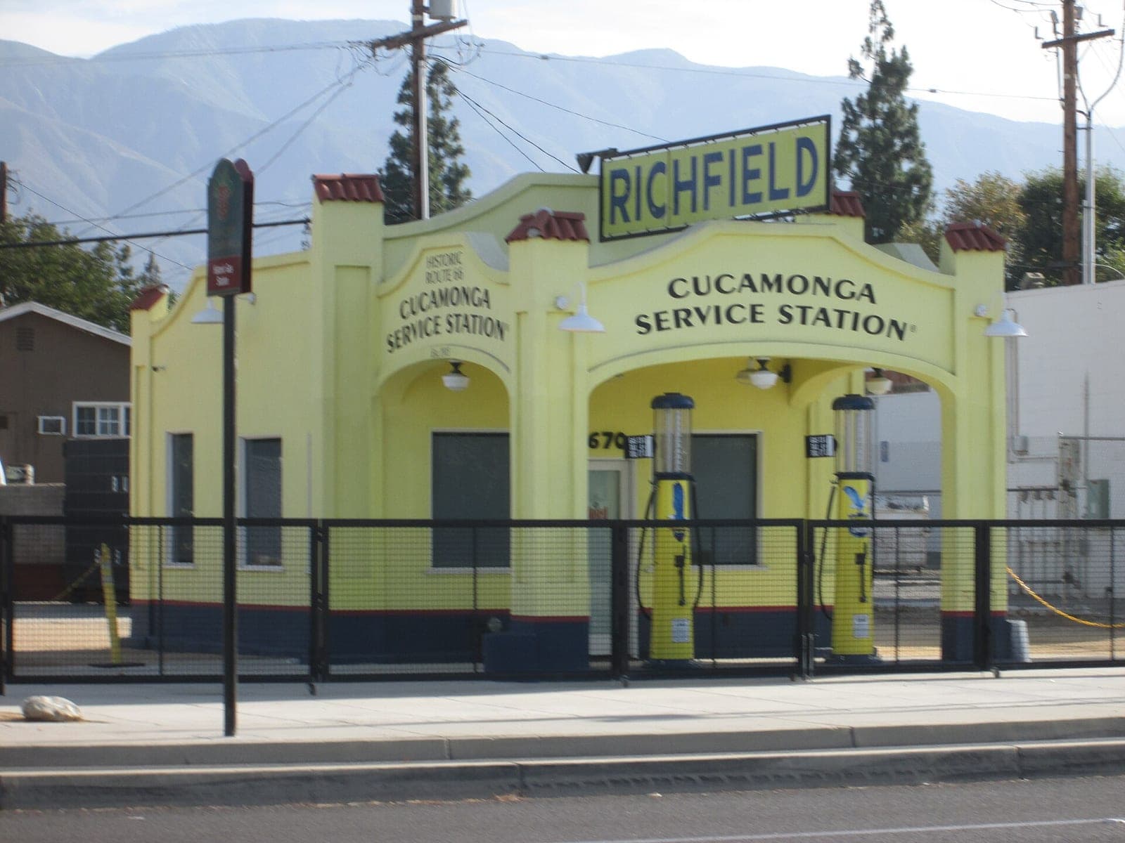 The restored Cucamonga Service Station, a small white 1915 filling station with vintage gas pumps on Foothill Boulevard