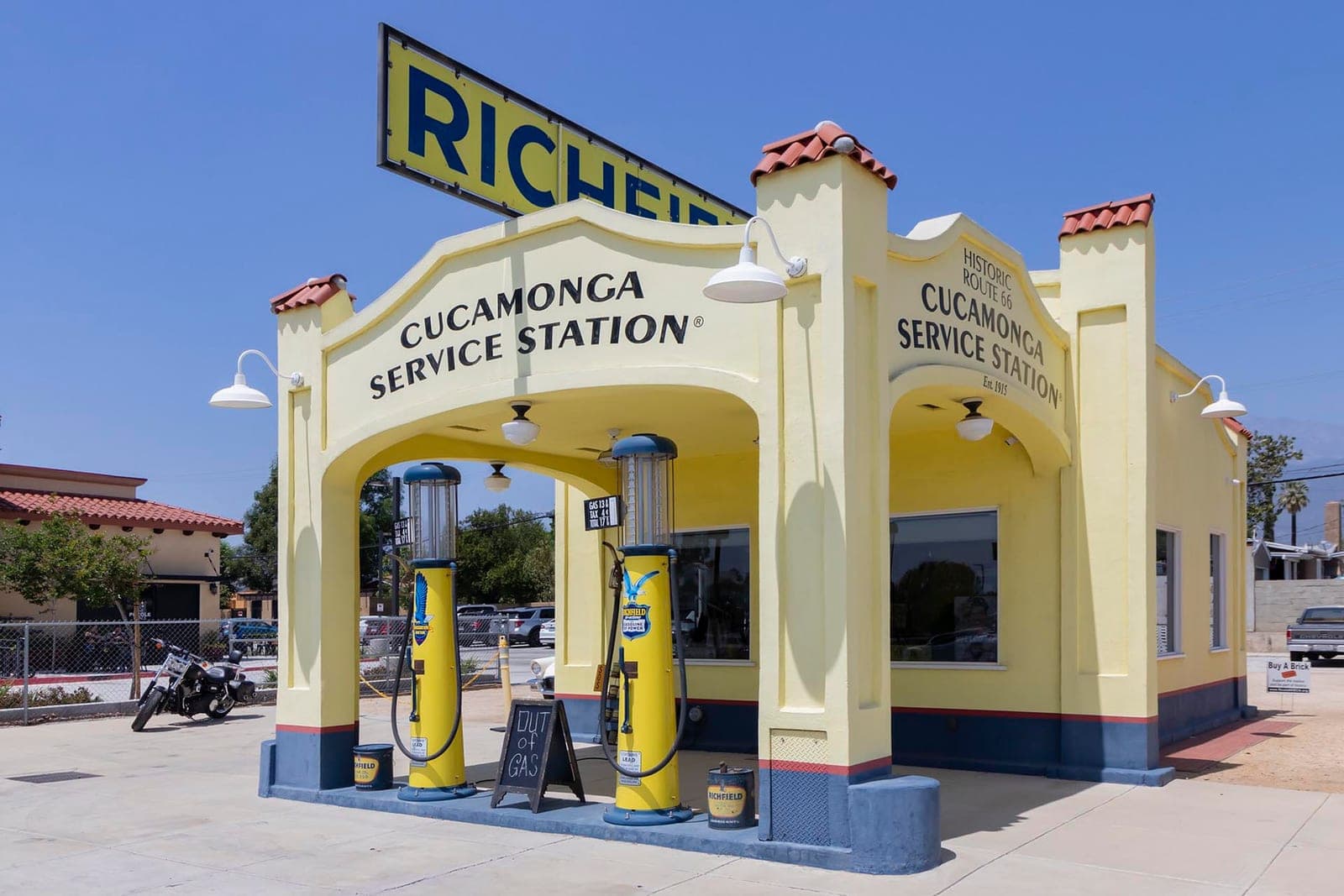 The twin Richfield gas pumps under the arched canopy of the Cucamonga Service Station on a clear summer afternoon