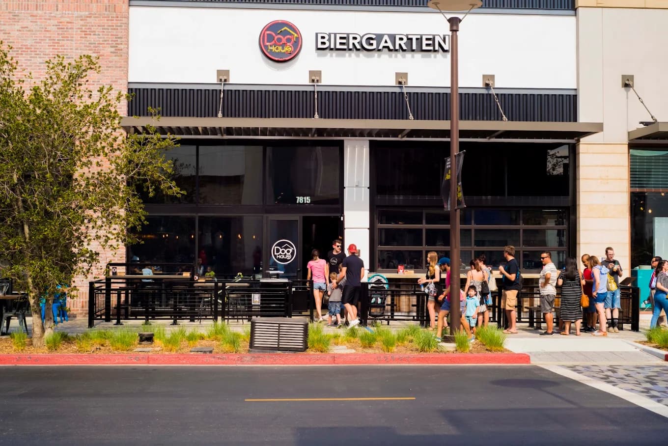 Exterior of Dog Haus Biergarten with a line of people at the patio railing outside