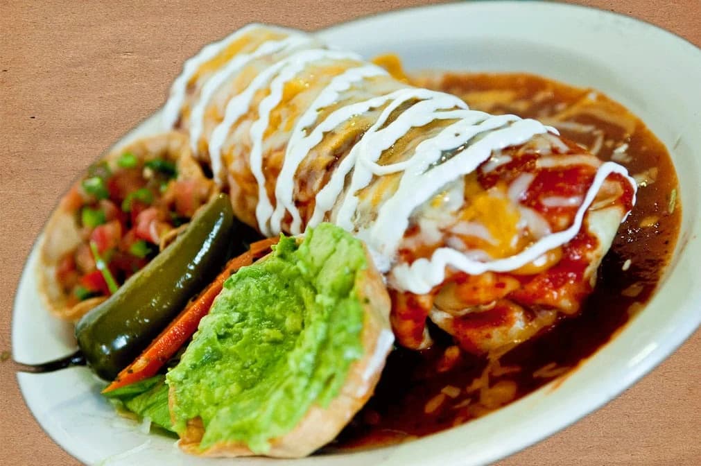 Wet burrito with red sauce, crema, guacamole and a jalapeño from El Ranchero Restaurant