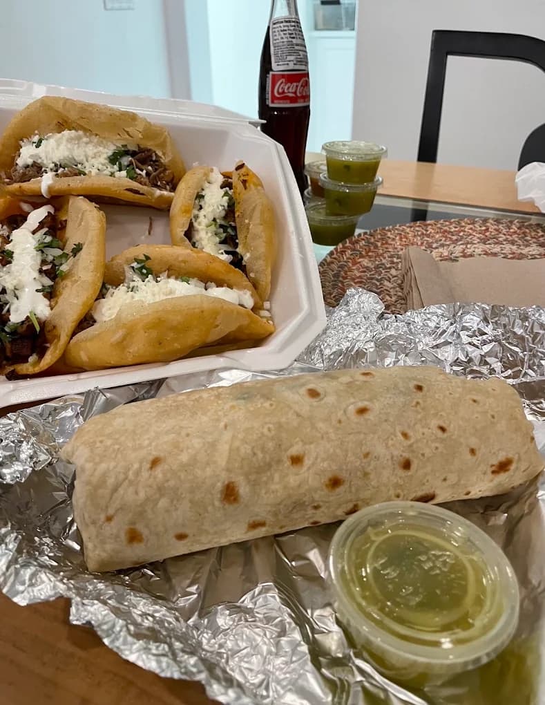 Foil-wrapped burrito with salsa verde and a box of quesadilla tacos from Fat Burrito