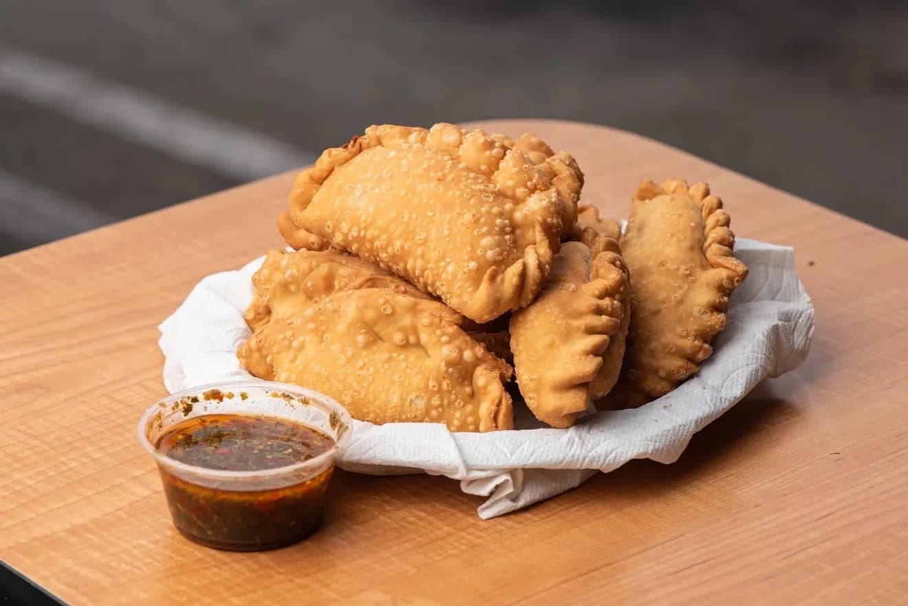 Basket of fried empanadas with chimichurri at Guido's/FURNO'S Pizza & Empanadas Argentinas