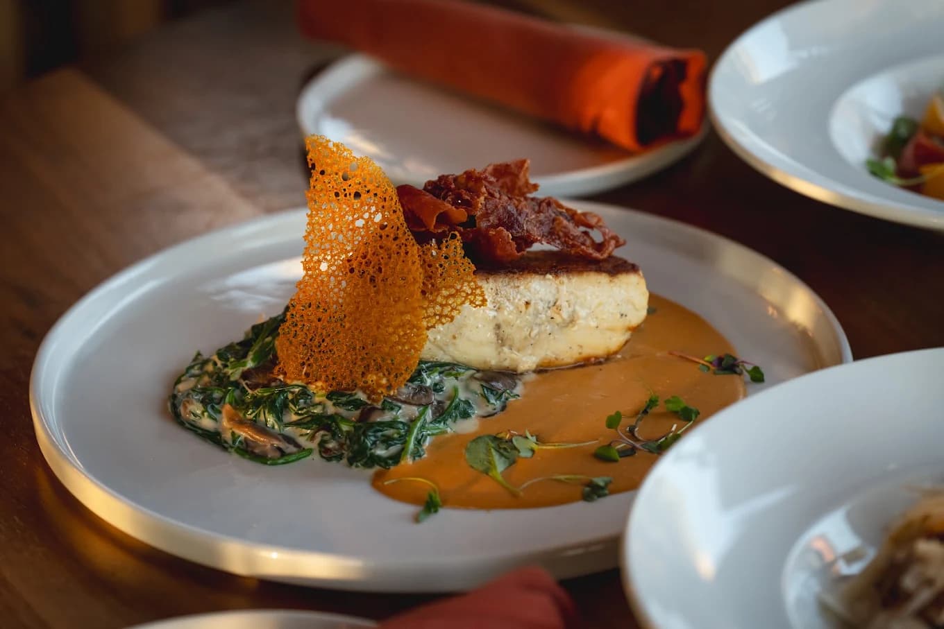Seared fillet over creamed spinach with crisped ham and a lace tuile at International Restaurant Village