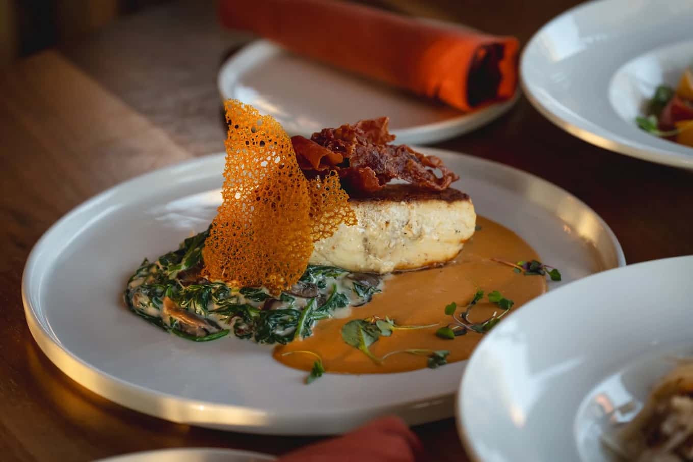 Seared fillet over creamed spinach with crisped ham and a lace tuile at International Restaurant Village