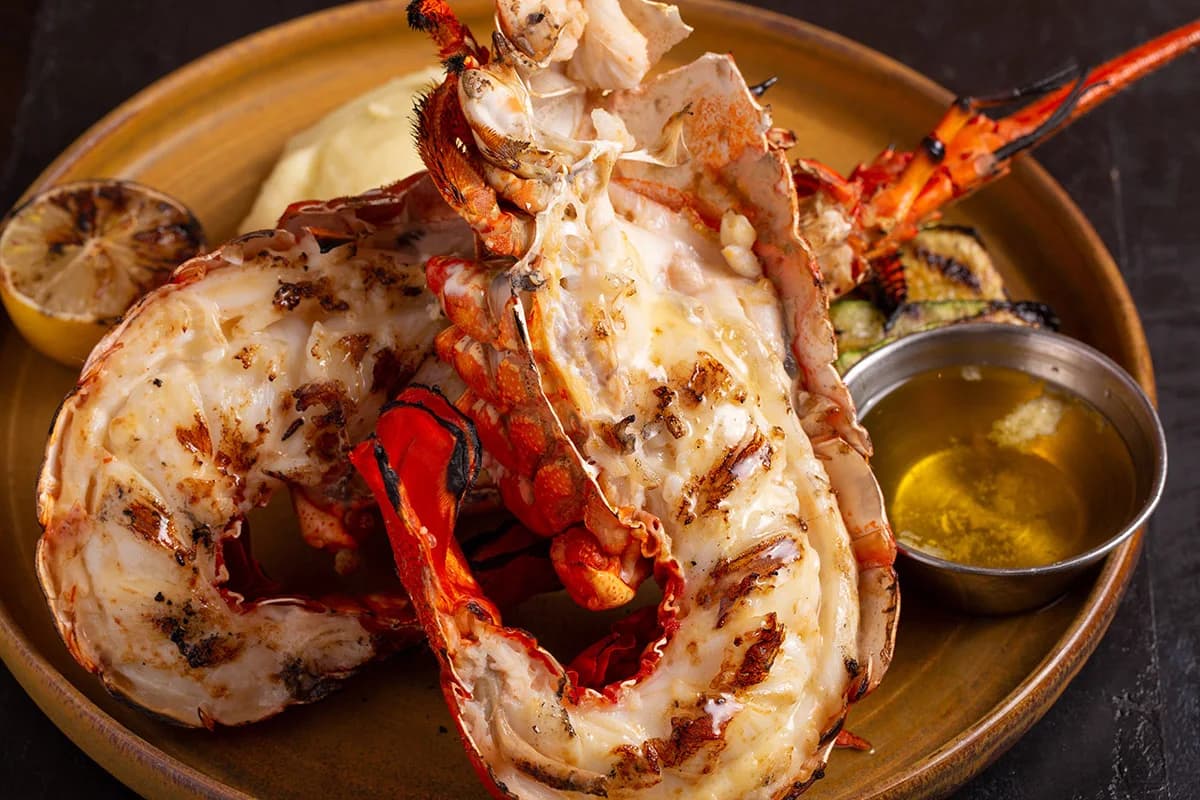 Grilled split lobster with melted butter, grilled lemon and vegetables at King's Fish House