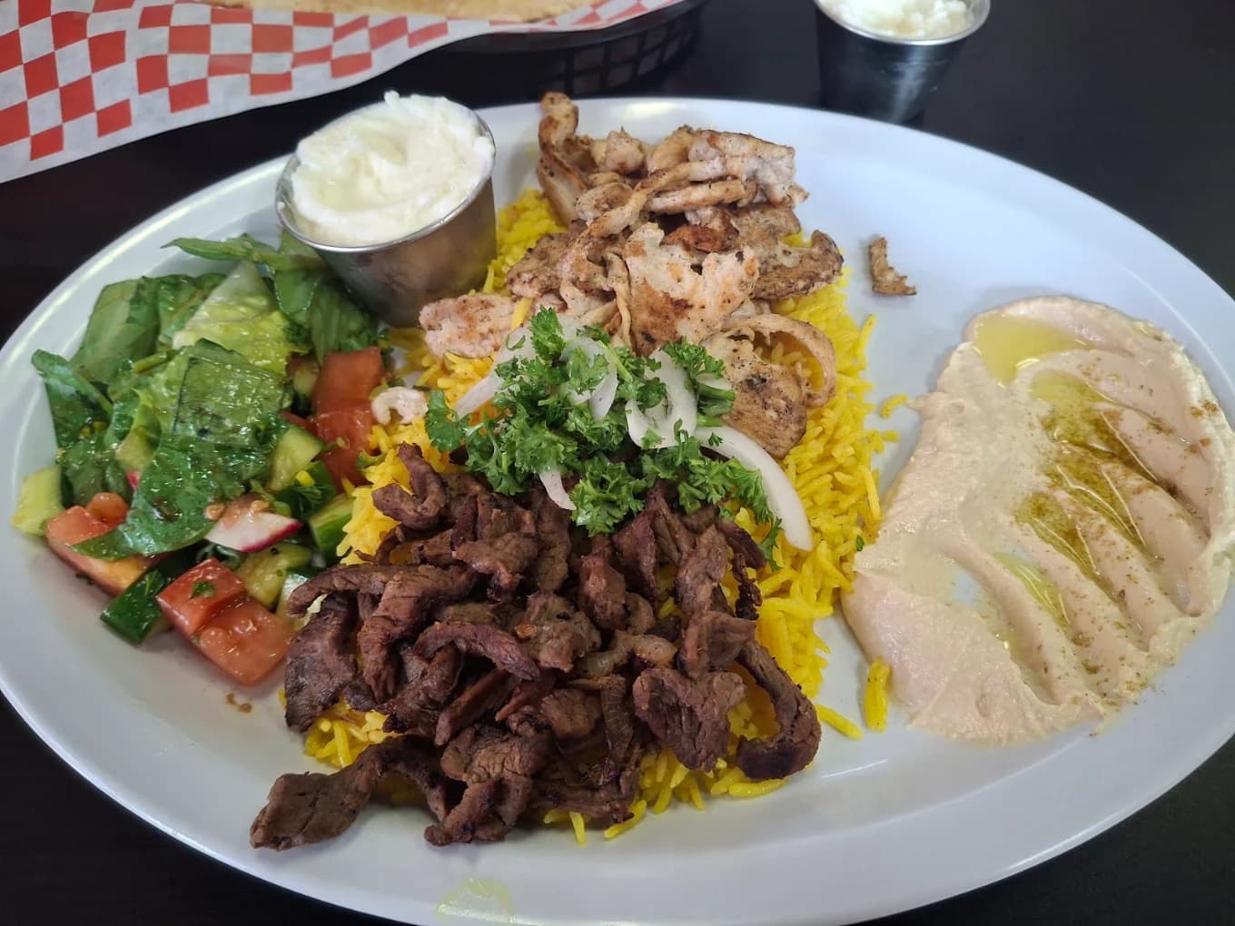 Chicken and beef shawarma plate with yellow rice, salad, hummus and garlic sauce at Layla Mediterranean