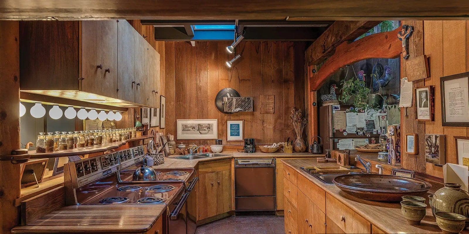The Maloof kitchen, wood-panelled with a rack of spice jars, hand-built cabinets and a thrown ceramic basin set into the counter