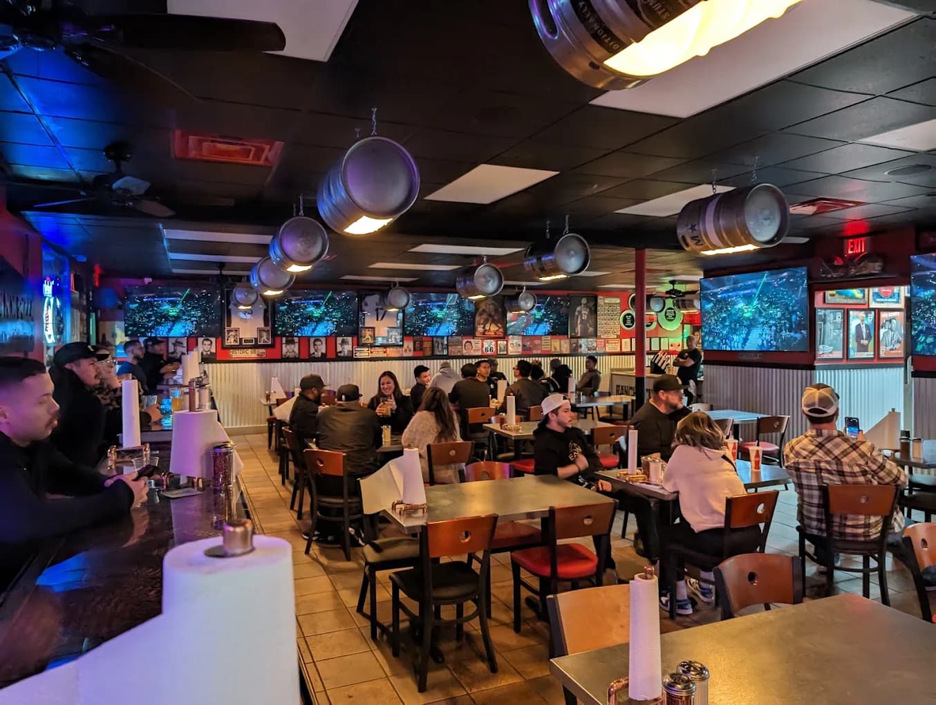 Dining room at My NY Sports Pizza with wall-mounted TVs, keg light fixtures and seated guests