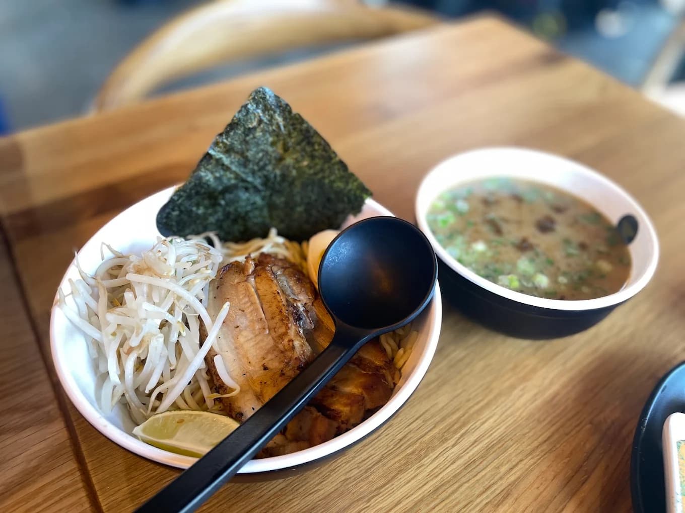 Tsukemen bowl with pork, bean sprouts, nori and lime beside a bowl of dipping broth at Silverlake Ramen