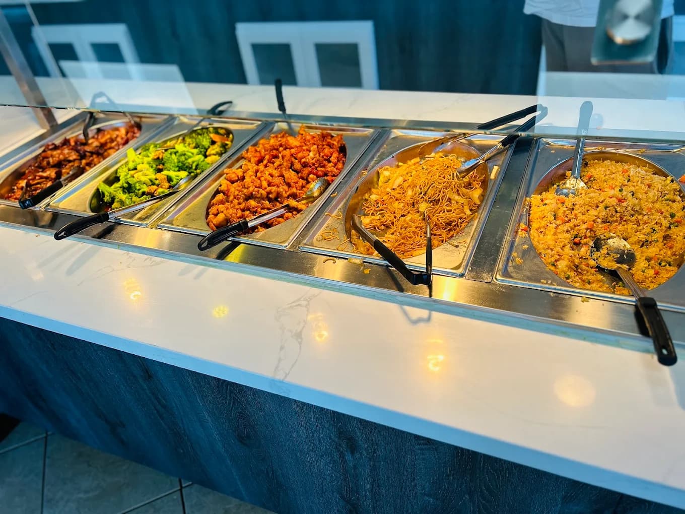 Steam-table trays of orange chicken, broccoli, noodles and fried rice at Sun's Wok & Mongolian BBQ