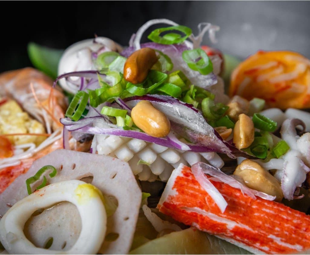 Close-up of hot pot ingredients with squid, shrimp, crab stick, lotus root and peanuts at Tang Bar 烫吧麻辣烫