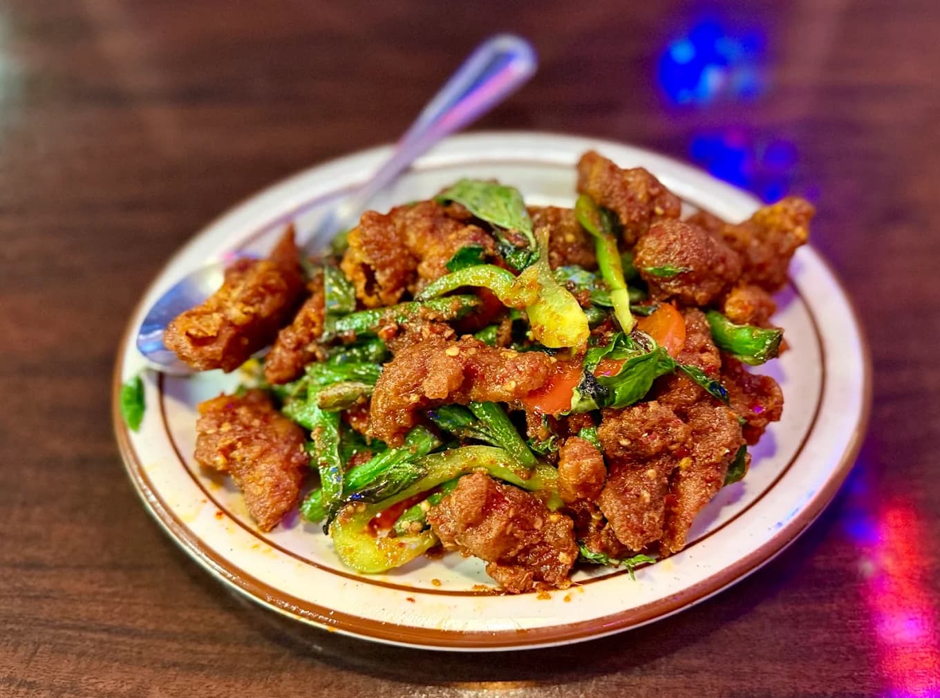 Plate of crispy stir-fried meat with green vegetables and tomato at Thai Diamond Bar.B.Q