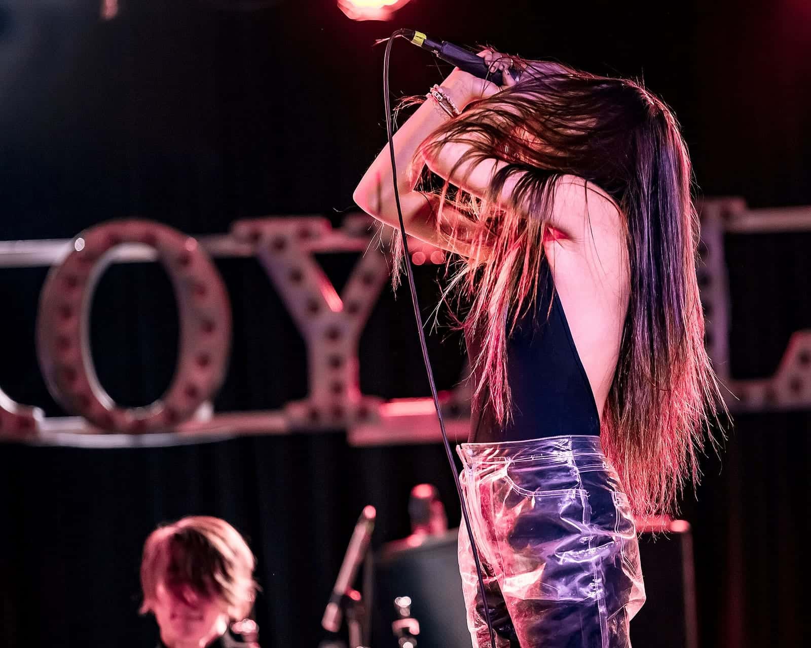 A band performing on stage under stage lights at the Glass House in Pomona