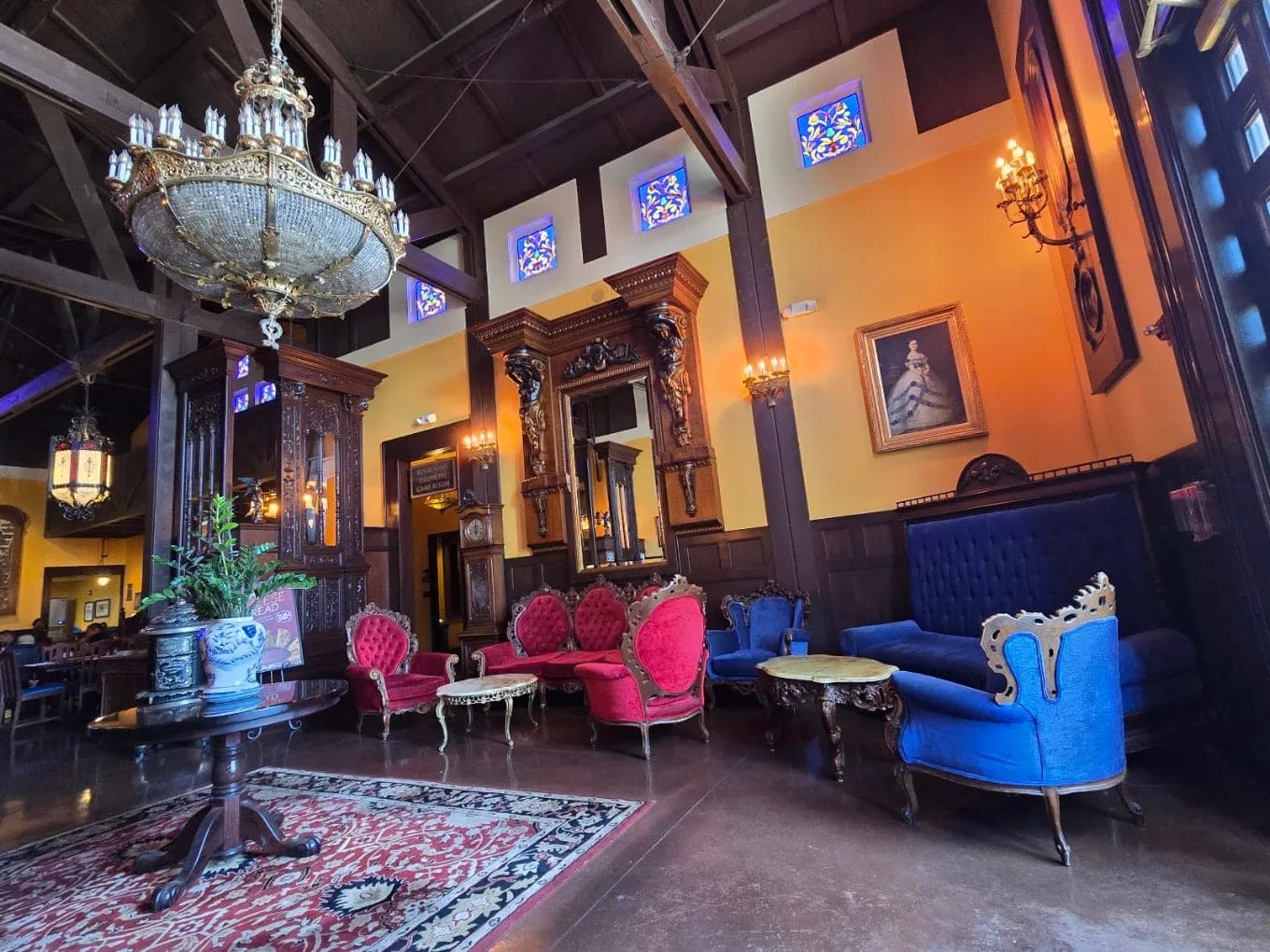 The lobby at the Old Spaghetti Factory, a chandelier over velvet settees in pink and blue on a patterned rug