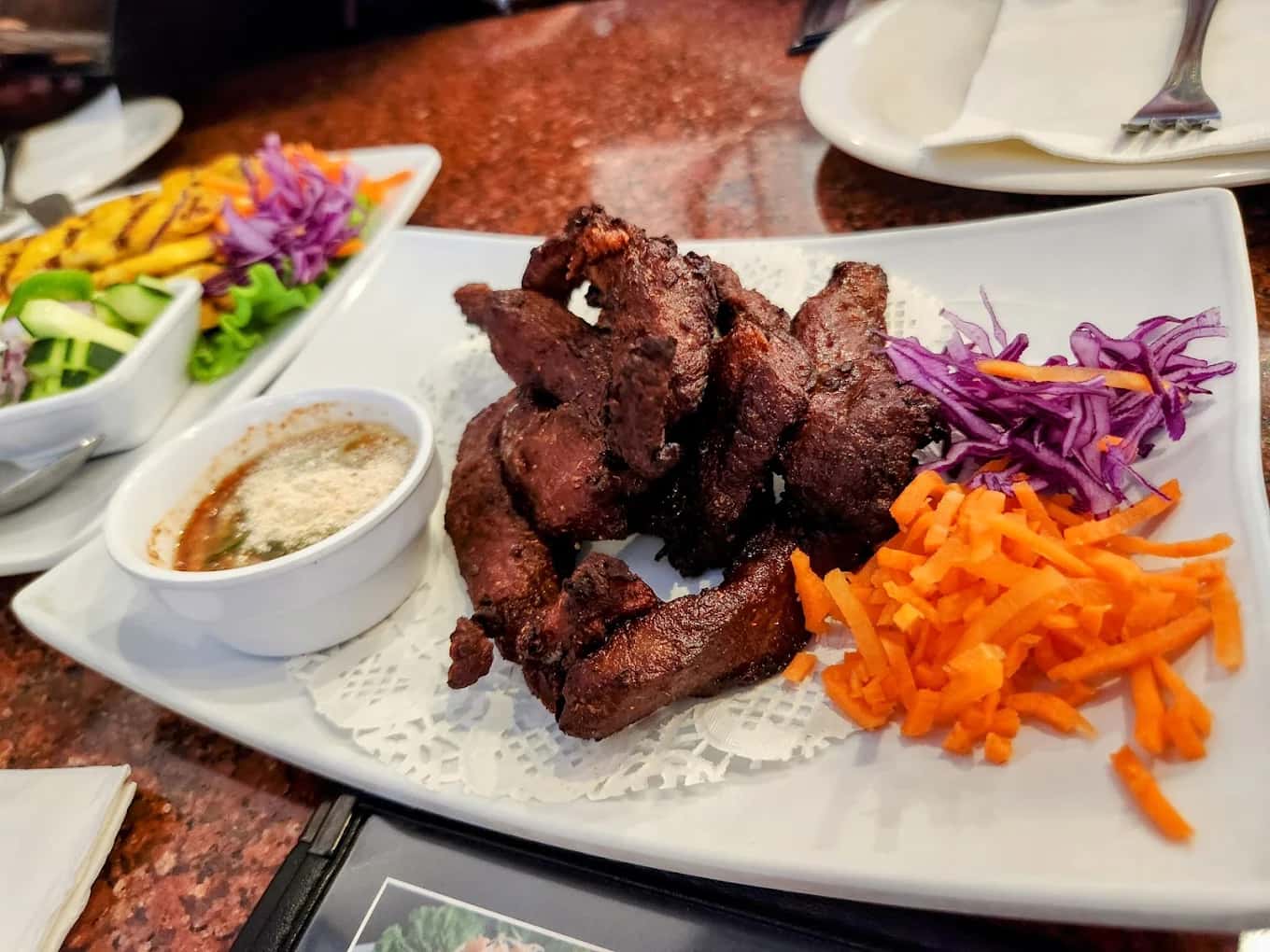 Plate of fried beef jerky with dipping sauce, shredded carrot and cabbage at Thippawan Thai Restaurant