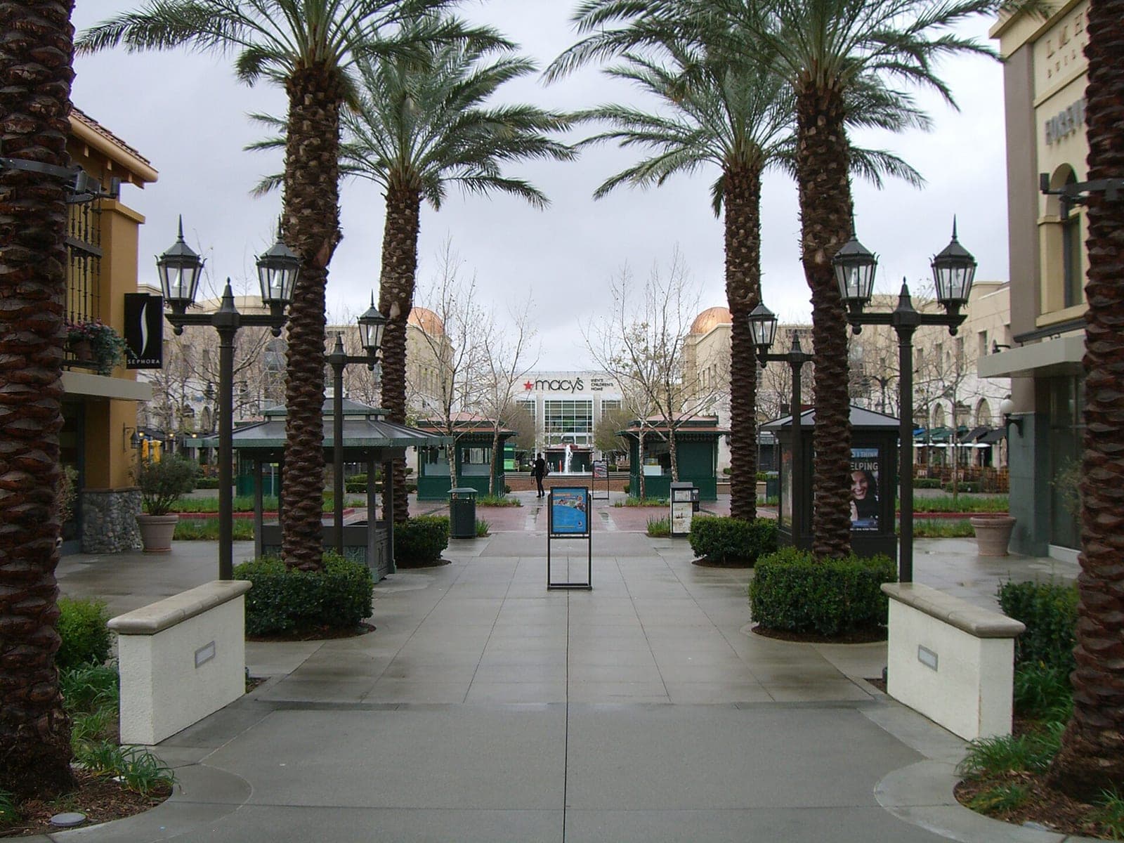 Chaffey Town Square at Victoria Gardens, a lawn plaza ringed by trees and open-air storefronts