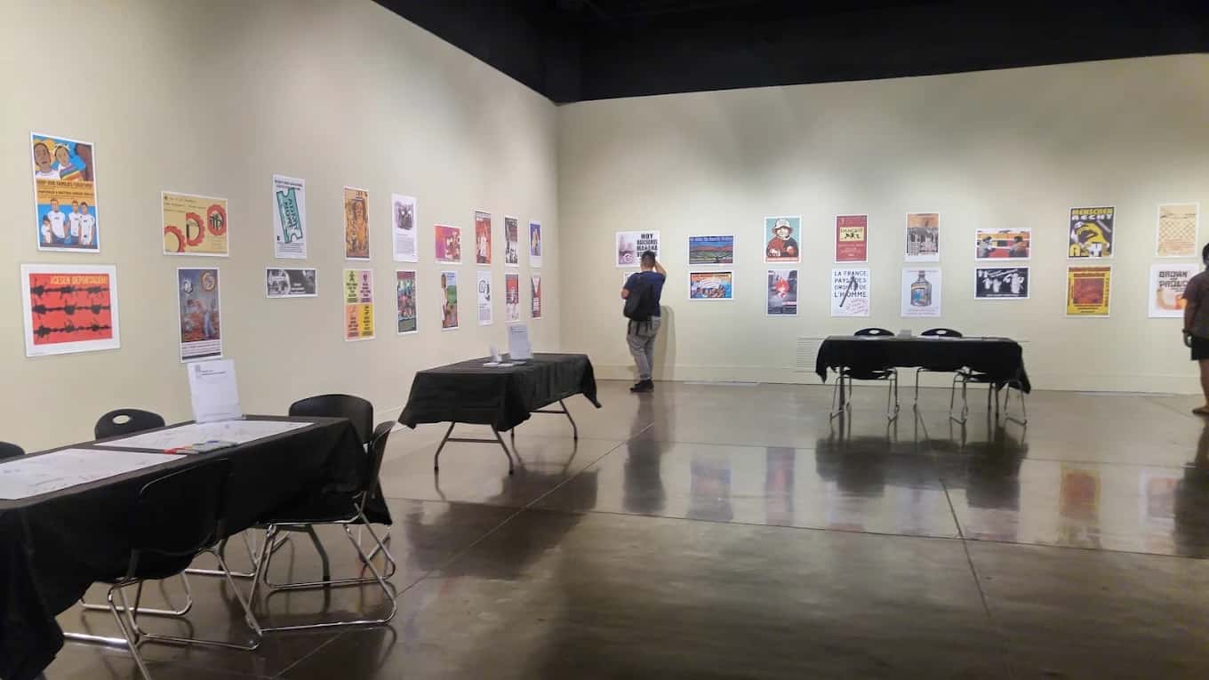 Gallery at Wignall Museum of Contemporary Art with poster prints on the walls and a visitor viewing them