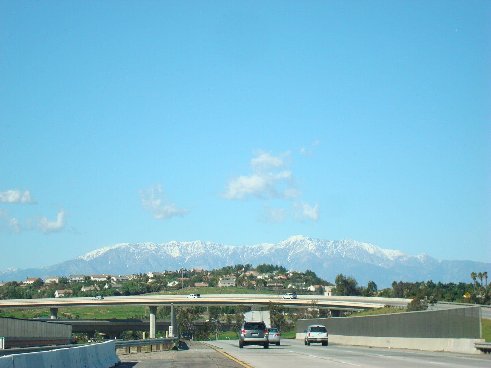 Interstate 15 heading north toward Rancho Cucamonga, with snow on the San Gabriel Mountains ahead