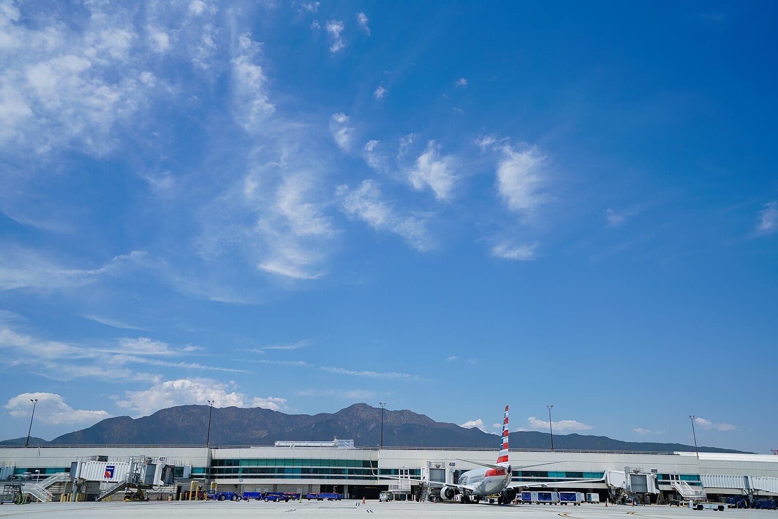 Ontario International Airport's terminal seen from the airfield, with the San Gabriel Mountains behind it